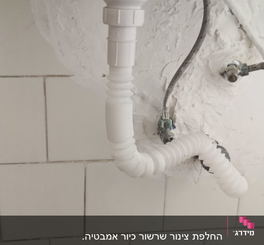 צינור ניקוז לבן מתחת לכיור עם חיבורים